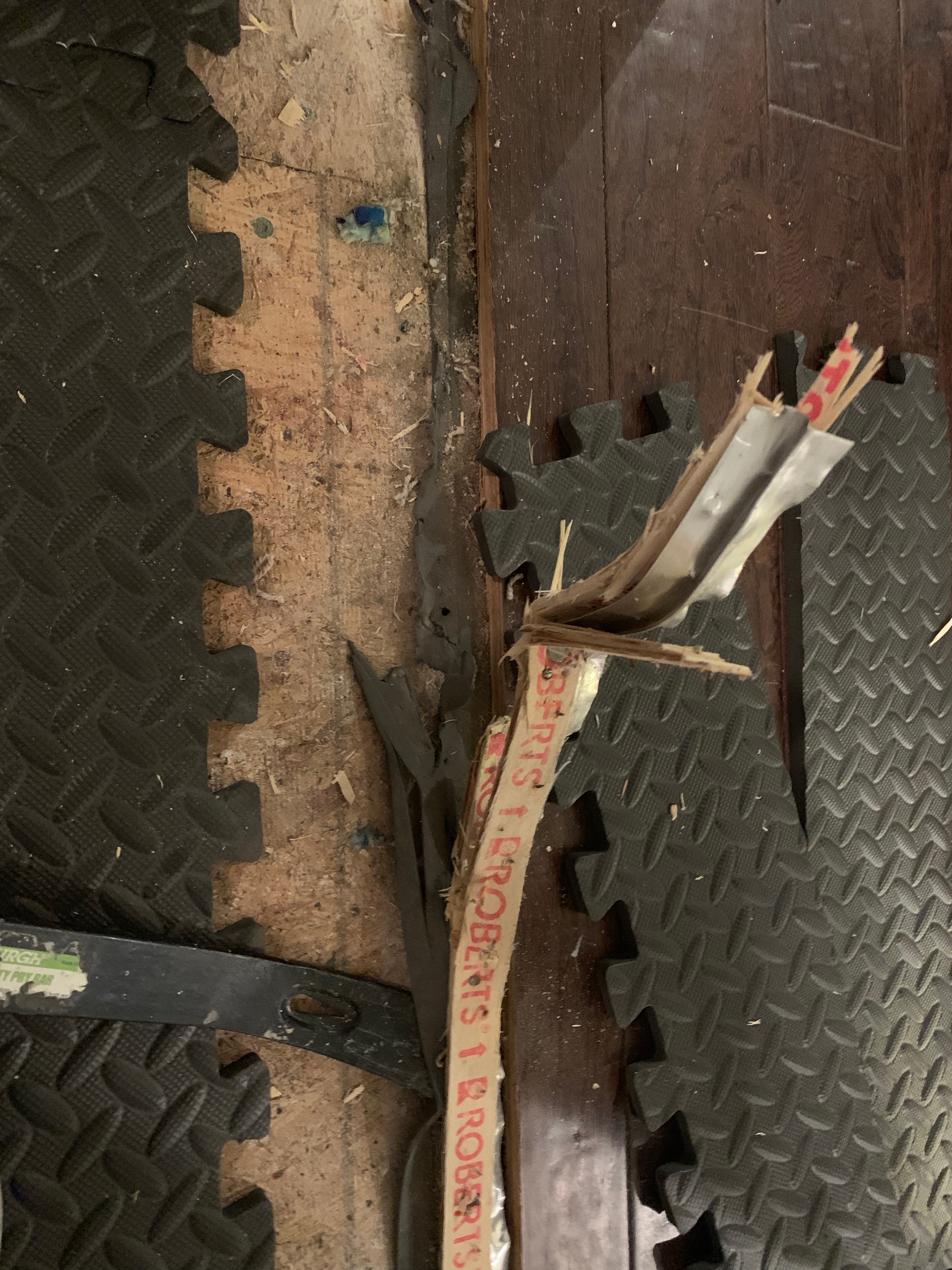 Mangled wood w/ nails next to rubber floor